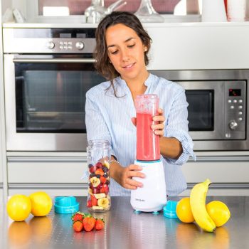 chica con batidora de vaso de smoothies en la cocina