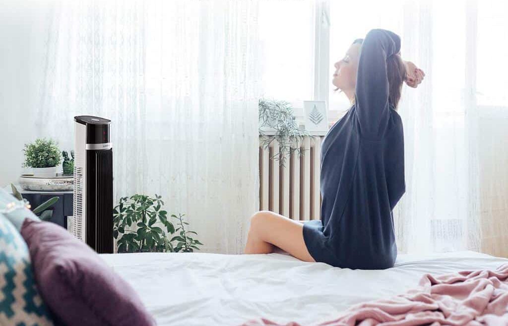 mujer disfrutando del ventilador de torre