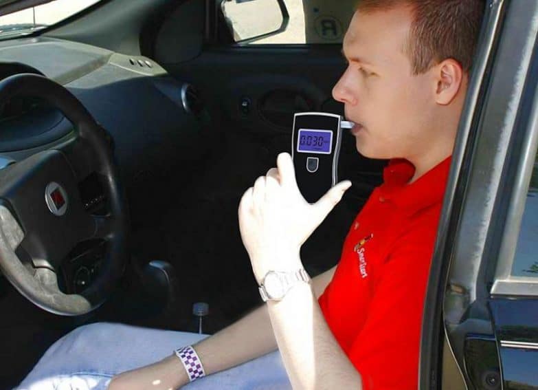 chico haciendo el test de alcoholemia con el alcoholimetro