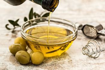 peligros del aceite de oliva echandose en un recipiente de cristal