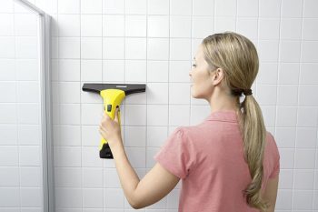 mujer limpiando baldosas con aspiradora limpiacristales