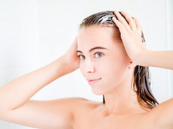 mujer aplicando protector de cabello