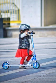 niña pequeña sobre un patinete