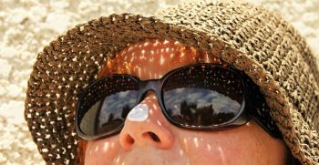 mujer protegiendo su rostro con gafas y gorra