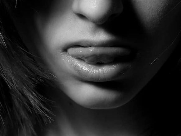 Cómo hidratar los labios de forma natural imagen 4 mujer pasando la lengua por los labios