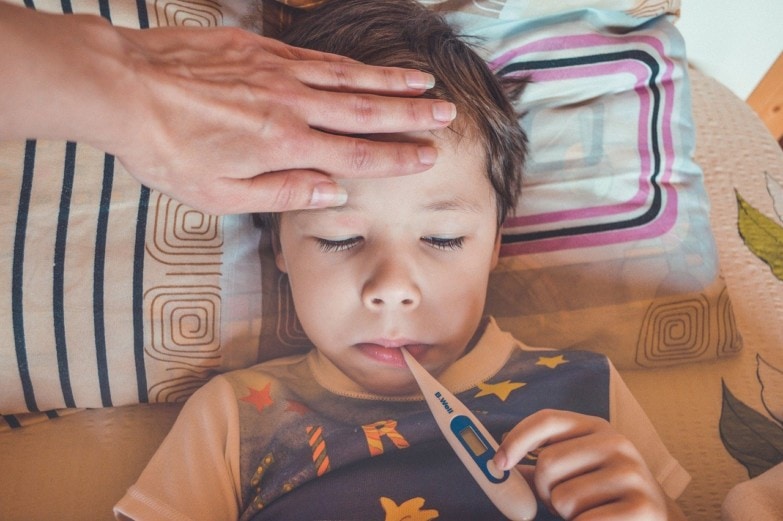 niño usando termómetros digitales