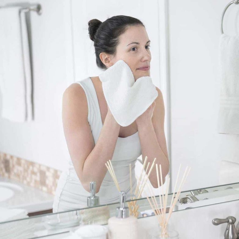mujer-limpiándose-la-cara-frente-al-espejo