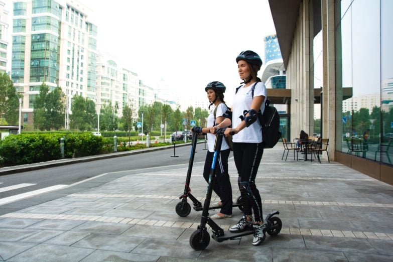 chicas usando patinetes eléctricos para desplazarse