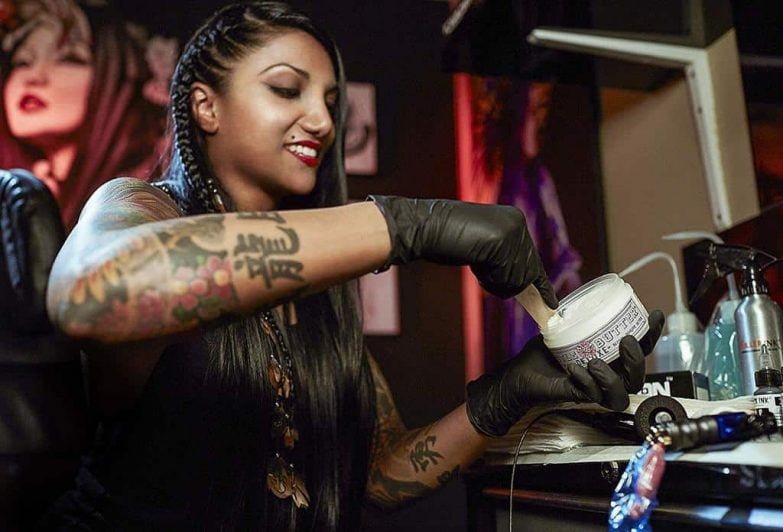 mujer usando crema para tatuajes