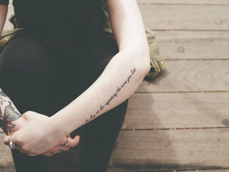 persona sentada con tattoo en el brazo
