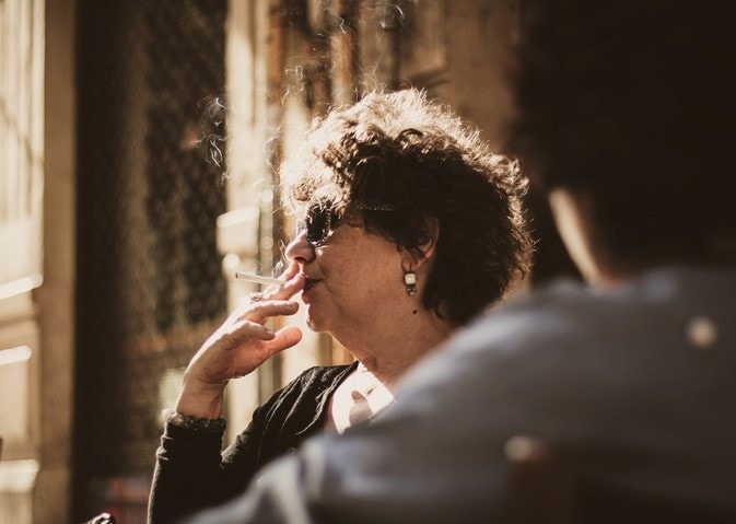 Consejos para eliminar el olor a tabaco del hogar imagen 1 Señora fumando un cigarrillo y llenando el aire con humo de tabaco