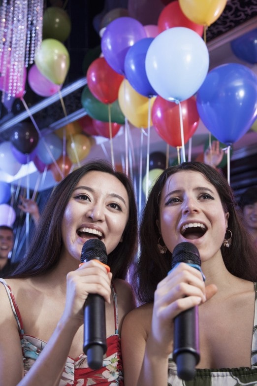 chicas-cantando-con-altavoz-karaoke-en-casa