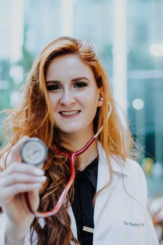Doctora sosteniendo un fonendoscopio para auscultar 