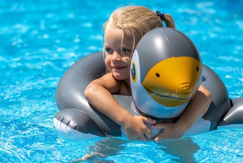 Niña en piscina desmontable con hinchable