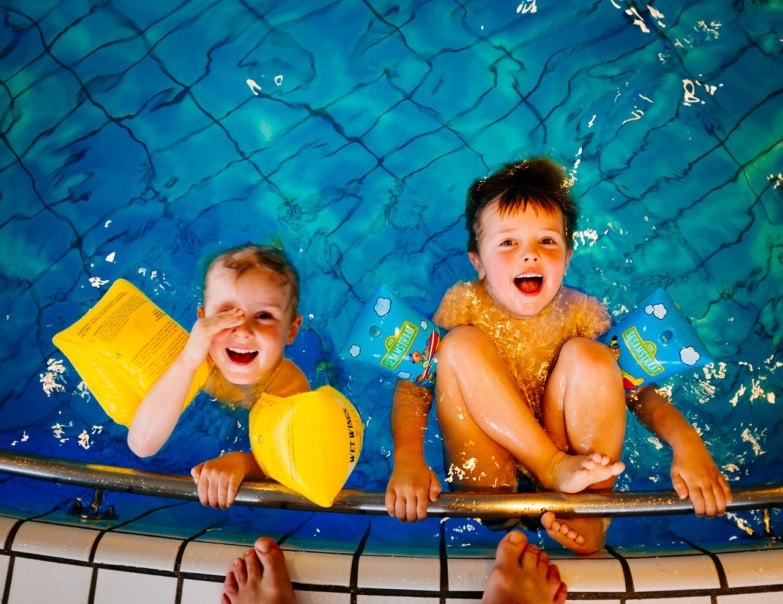 Niños en la piscina después de una limpieza con el robot limpiafondos