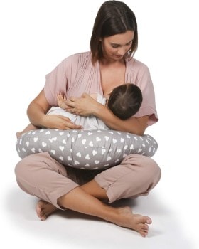 Mujer joven usando un cojín de lactancia para amamantar al bebé