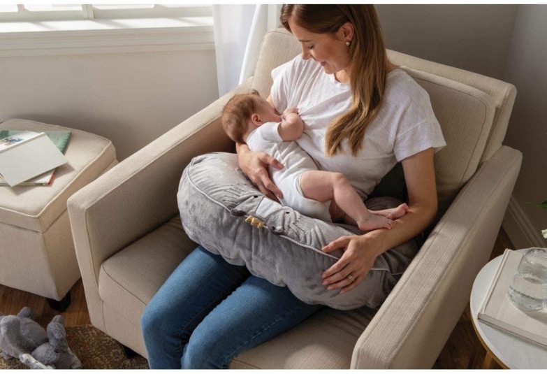 mujer usando almohada de lactancia para amamantar al bebé