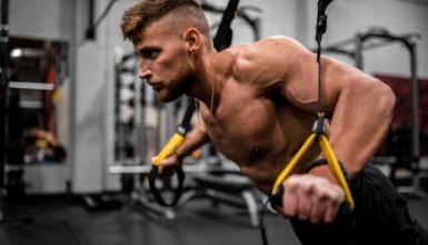 chico haciendo deporte con cintas trx