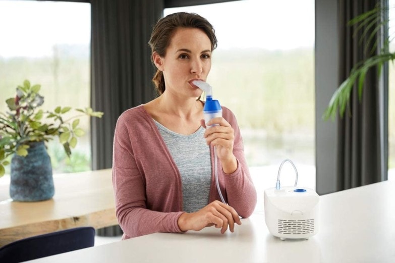 mujer usando nebulizador para sus problemas respiratorios