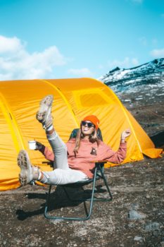 Joven sentada en silla plegable de camping