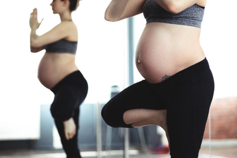 Mujer embarazada haciendo gimnasia.