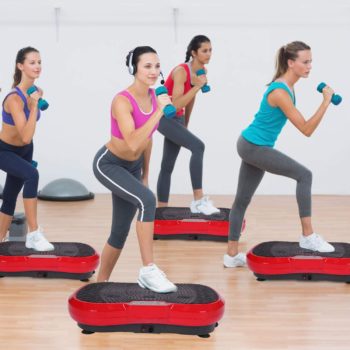 Mujeres haciendo gimnasia con plataformas vibratorias.