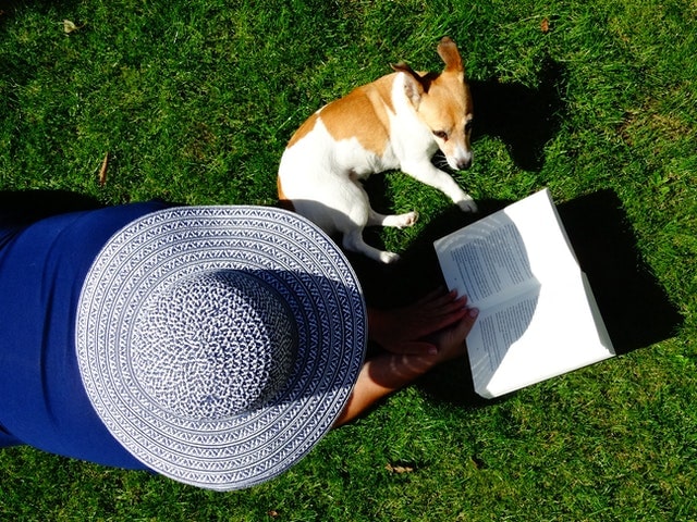 Lectura de libro en el jardín con mascota.