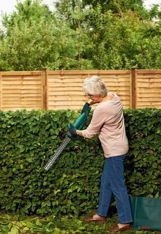 señora podando un seto con cortasetos de la marca Bosch