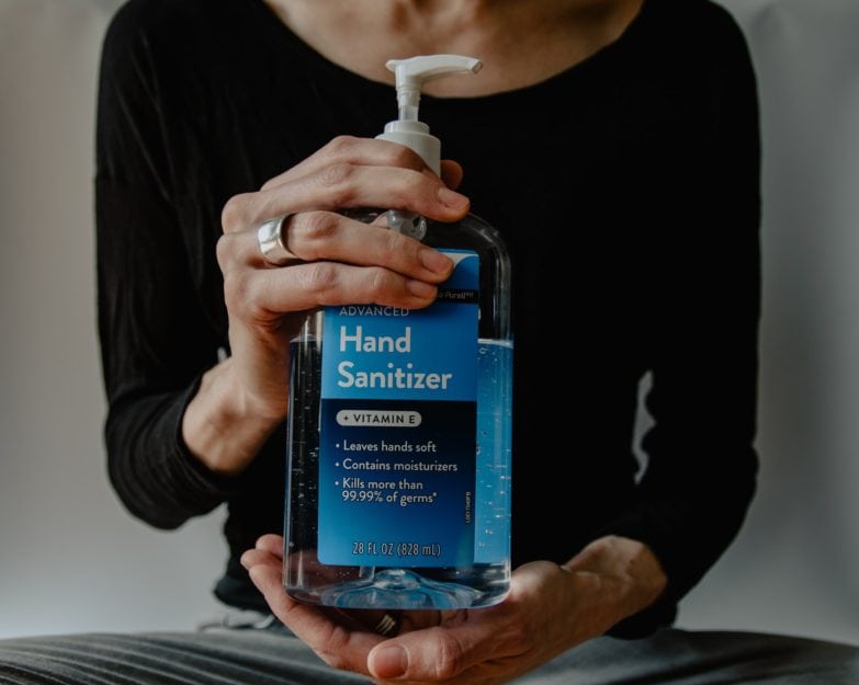 Guía para comprar la mejor crema de manos imagen 30 mujer mostrando un frasco de alcohol en gel