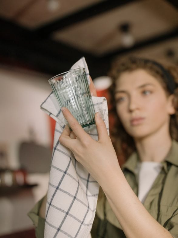 Chica puliendo un vaso de vidrio