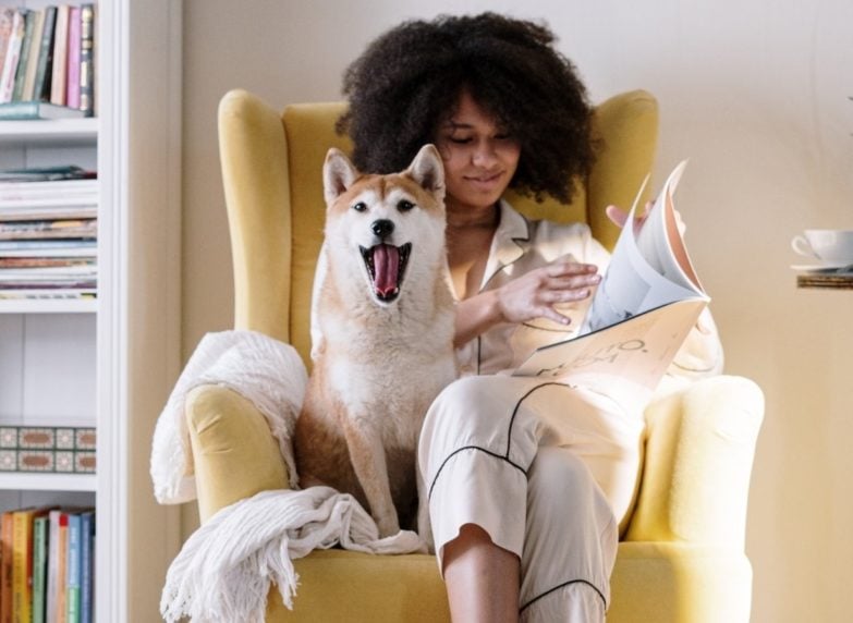 Mujer con perro en sillón con reposapiés