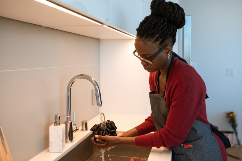 Los mejores grifos de cocina a la venta imagen 1 Mujer usando grifo de cocina