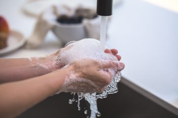 persona lavándose las manos con agua del grifo