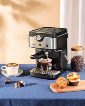 Cafetera Nespresso en una mesa con varios tipos de café y magdalenas