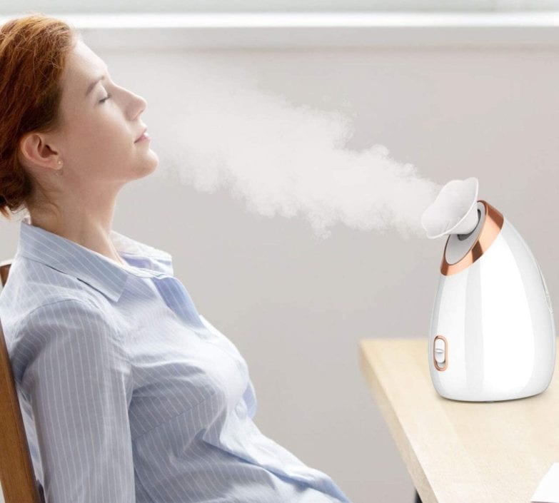 mujer frente a un vaporizador facial