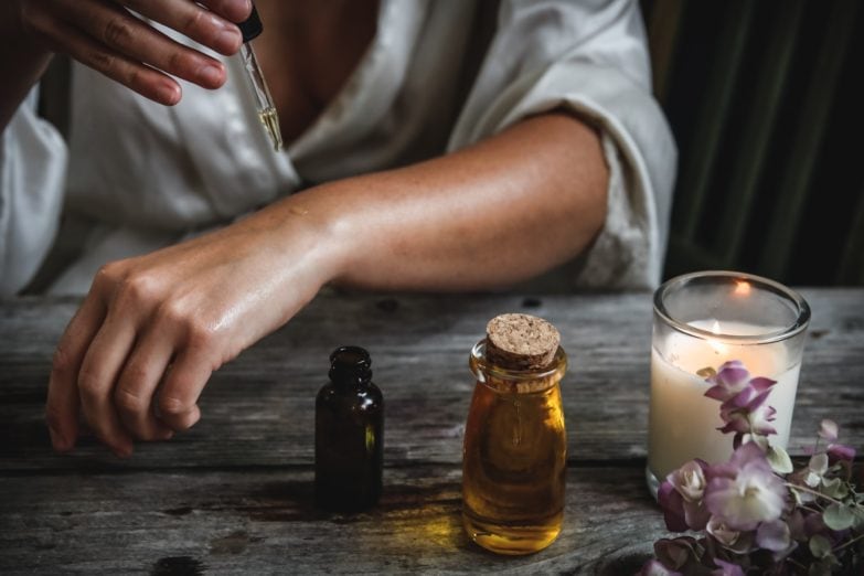 mujer aplicándose aceite esencial en la mano