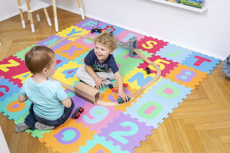 Niños jugando sobre una alfombra puzzle para bebés