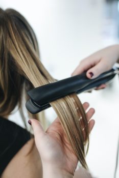 planchando el pelo con una plancha de pelo de placas de tamaño medio