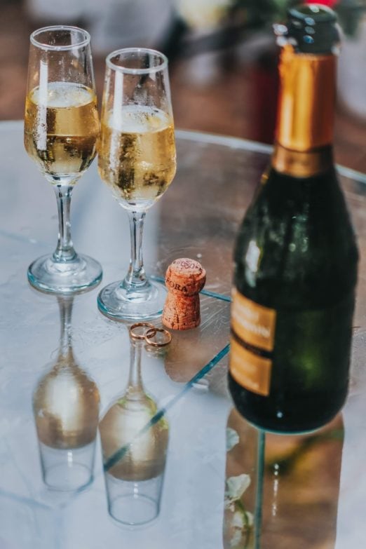 Cómo conservar una botella de vino abierta de manera correcta imagen 1 botella de vino blanco descorchada junto a 2 copas