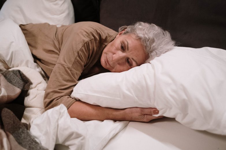 mujer mayor acostada en una cama
