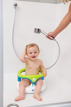 bebé sentado en una silla de baño para bebé mientras lo bañan con regadera