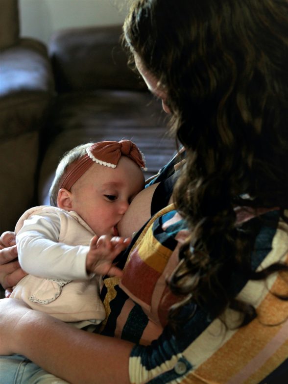 mujer sentada en un sillón de lactancia amamantando a un bebé