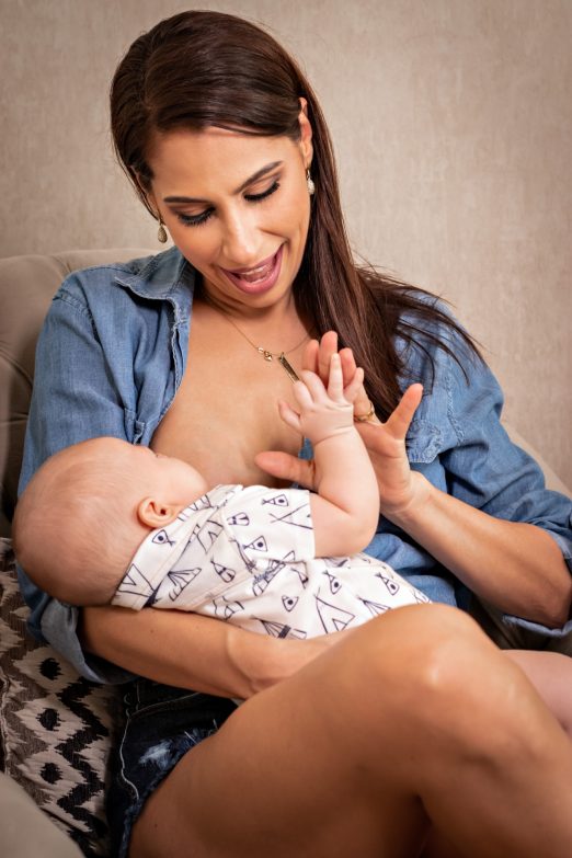 mujer sentada en un sillón de lactancia amamantando a un bebé