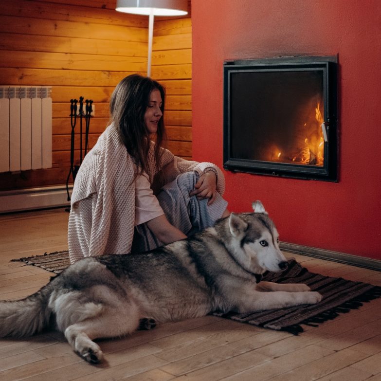 Mujer y perro frente a estufa