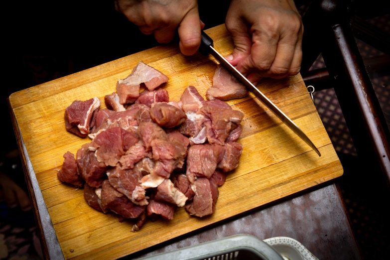 persona picando carne de res con un cuchillo