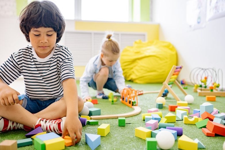 niños jugando en una habitación llena de juguetes